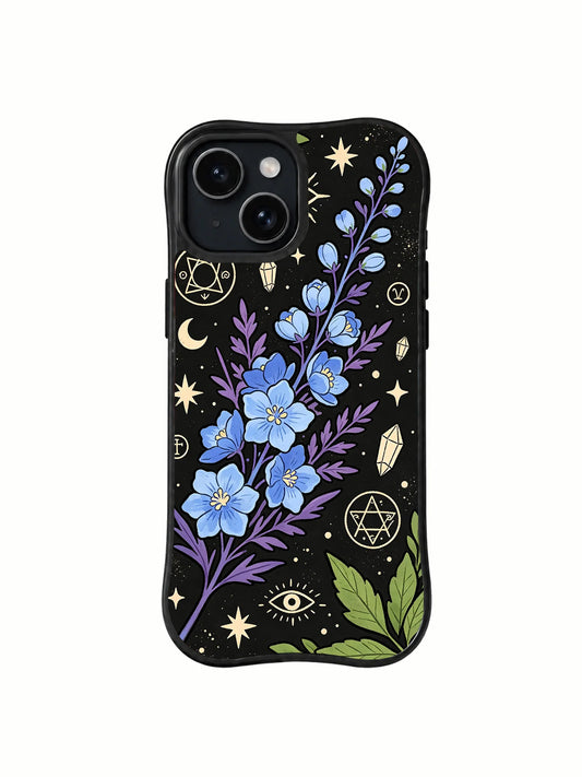 Black iPhone 15 Plus case with blue and purple flowers, green leaves, stars, crescent moon, eye, crystal, and pentacle-like symbols
