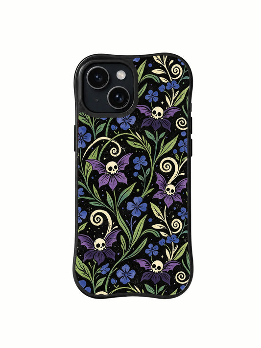 Black iPhone 15 Plus case with small ivory skulls among purple and blue flowers, green leaves, and curling pale vines