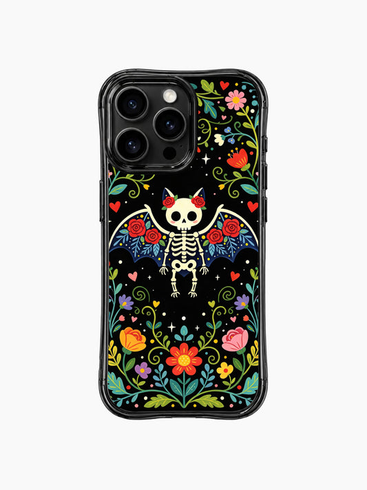 PhoneCasing iPhone 16 pro max case featuring a whimsical skeleton bat with roses, Day of the Dead folk art design with colorful flowers on black background.