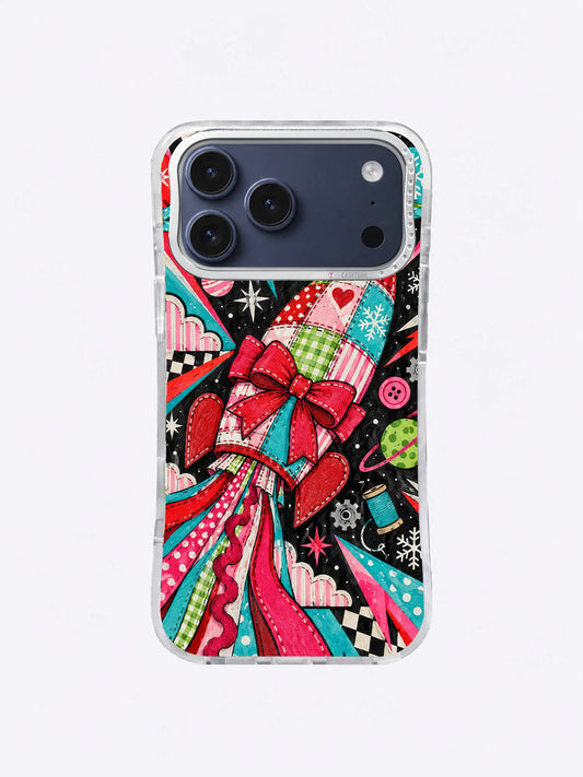 Patchwork Bow Comet artwork on an iPhone case with a red bow, stitched rocket panels, striped ribbon trails, stars, buttons, and checkerboard shapes