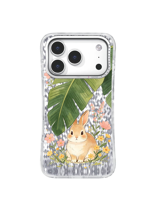 Rabbit sitting among wildflowers beneath green leaves on a clear iPhone 17 Pro case.