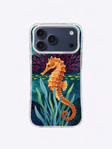 Orange seahorse beside teal sea grass and burgundy coral on a deep ocean background
