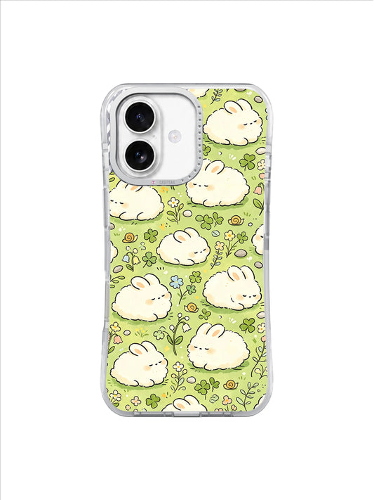 Clover Nap Bunnies: Yuvarlak krem tavşanlar açık yeşil zeminde yonca, küçük çiçekler ve kıvrımlı çimlerin arasında dinlenir.