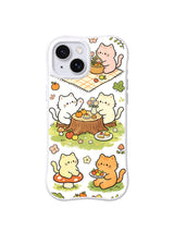 Sunlit Blanket Picnic Friends: Kediler kütük masa ve kareli battaniye çevresinde sepetler, fincanlar ve atıştırmalıkları paylaşır.
