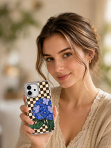 Lifestyle portrait with the blue hydrangea and snail iPhone 17 case.