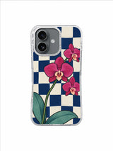 Three layered orchid blooms and pale teal leaves on a checkerboard iPhone 17 case