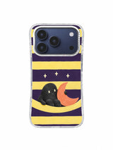 Charcoal creature resting beside a coral crescent in a pale lemon cradle on an iPhone 17 Pro case