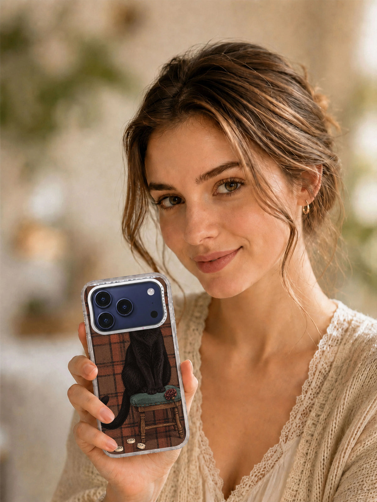 Lifestyle view of a woman holding The Black Cat’s Paper Crown iPhone 17 Pro case