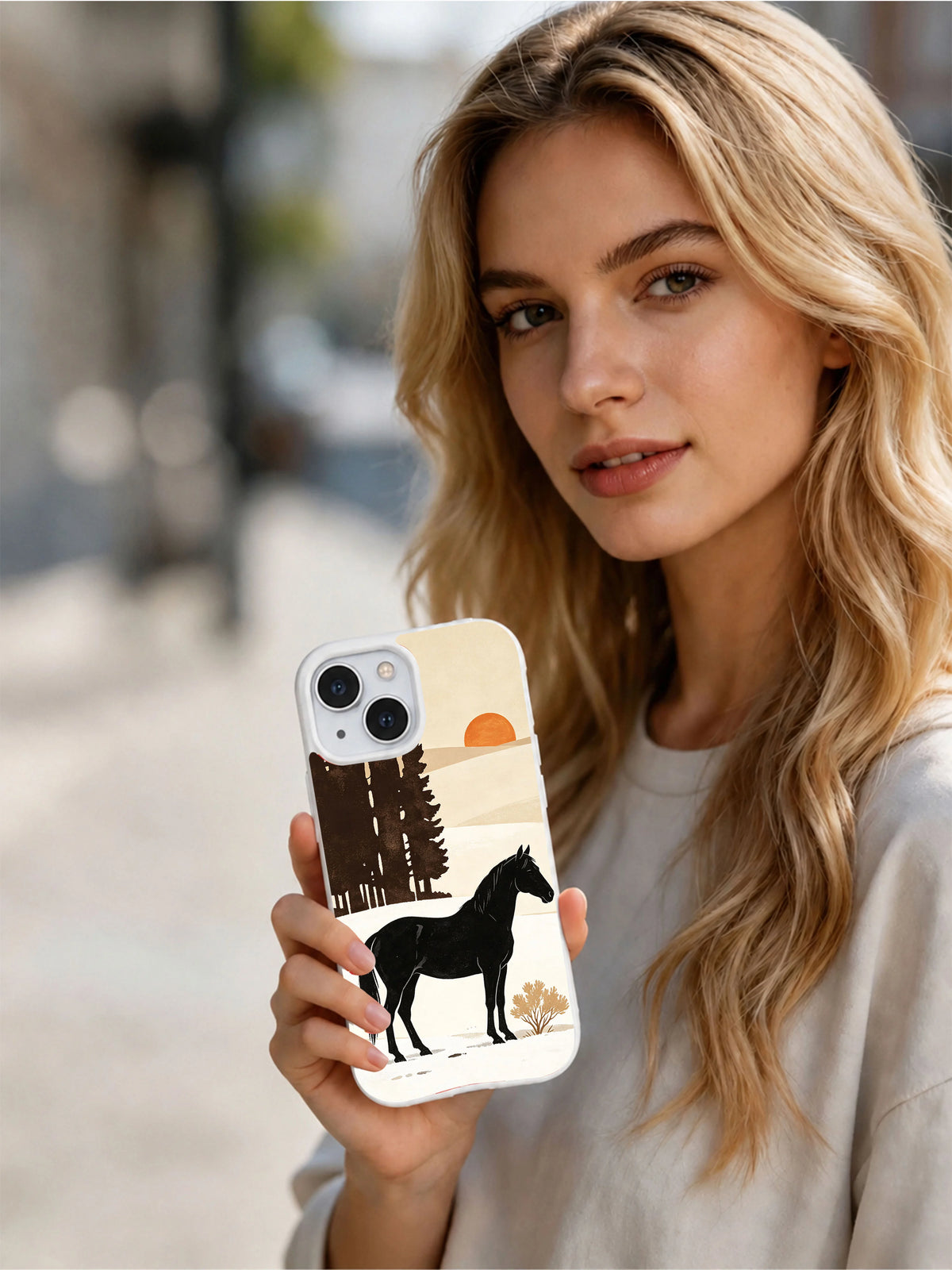 Person holding the Black Horse Winter white iPhone 13 case outdoors