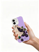 Hand holding a white iPhone 16 case with lavender blackberry pocket artwork
