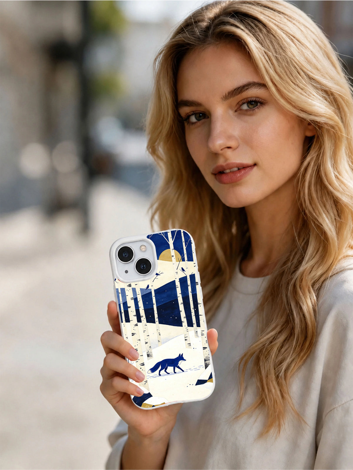 Lifestyle view of a person holding the Blue Fox Crossing iPhone 13 case with cobalt woodland art