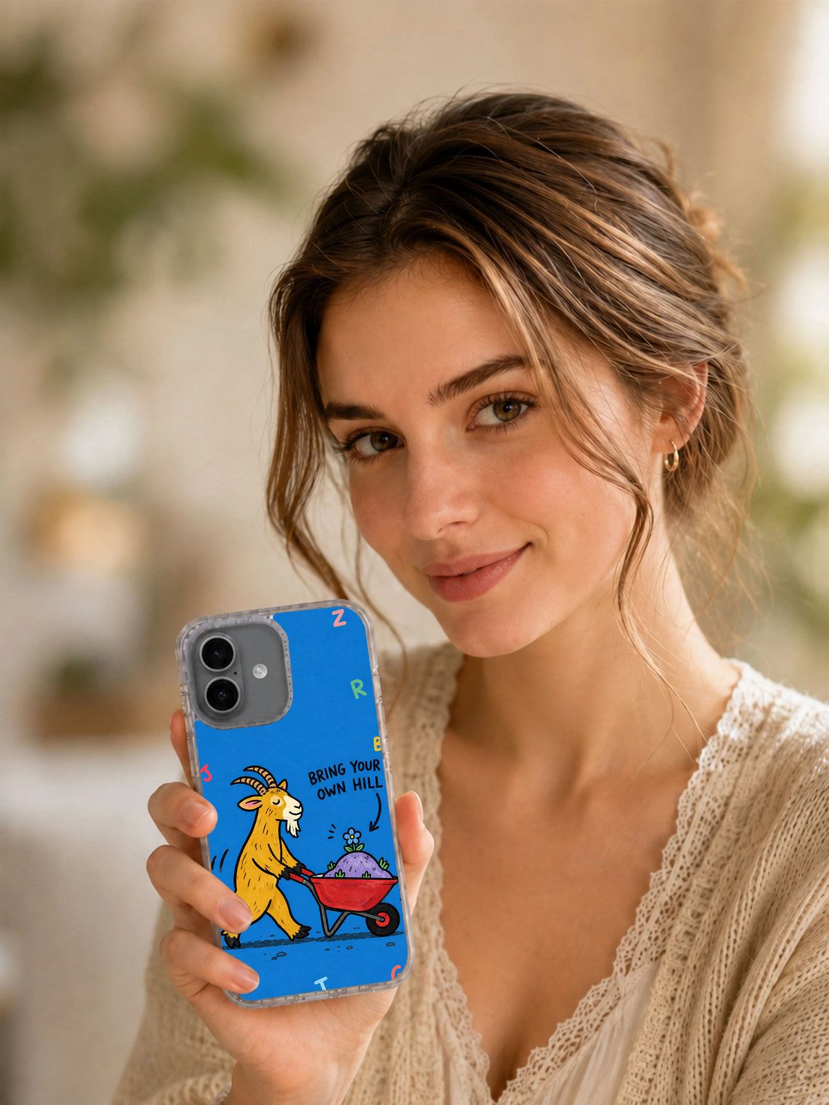 Lifestyle view of a woman holding the Bring Your Own Hill iPhone 16 case