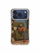 Charcoal cat holding a terracotta book in a cozy olive reading chair on an iPhone 17 Pro case
