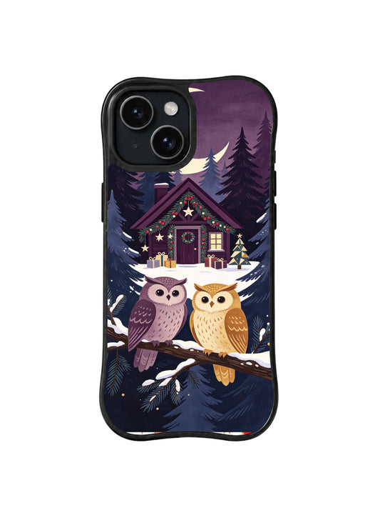 Black iPhone 14 case with two purple and ochre owls below a snowy moonlit Christmas library cottage