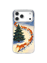 Copper fox family follows a circular snow trail around a dark fir on an iPhone 17 Pro case