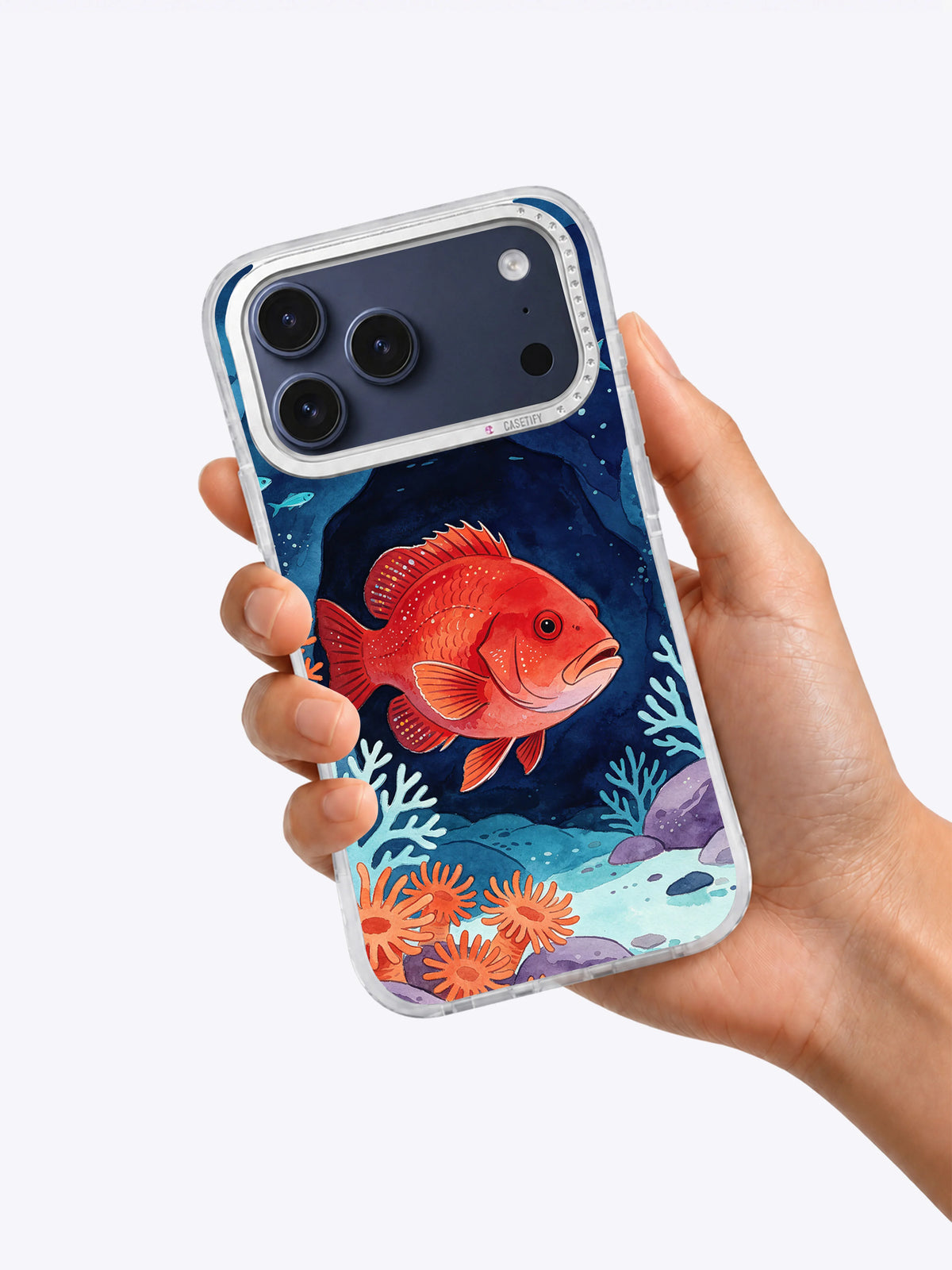 Crimson Reef Guardian coastal art iPhone case held in hand