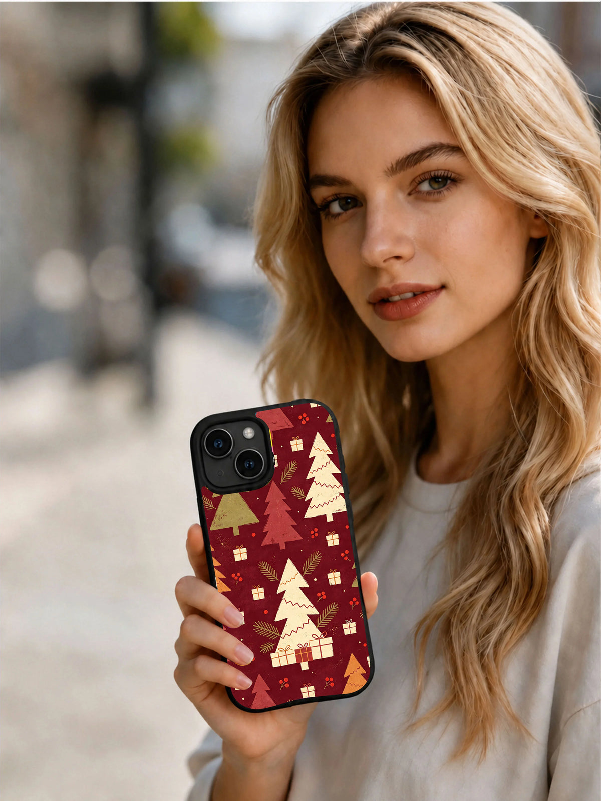 Person holding the Crimson Tree Parade vintage Christmas iPhone 15 case