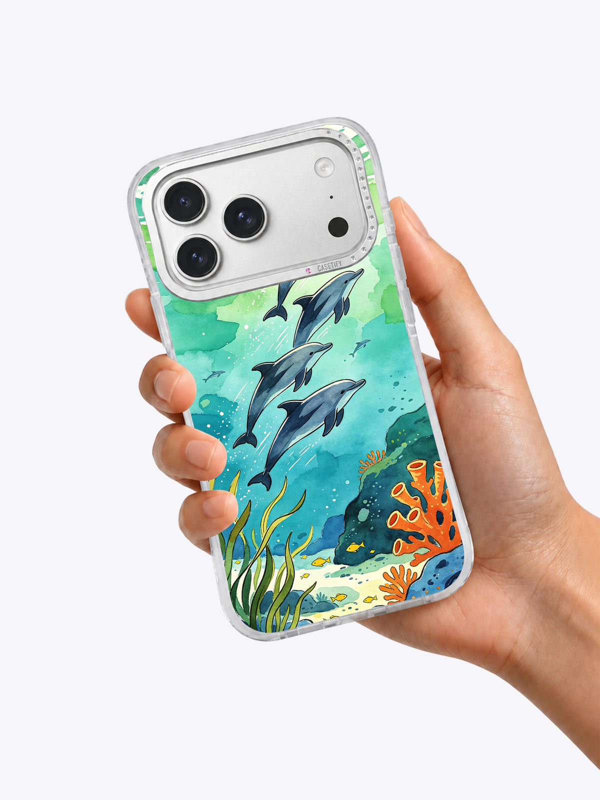 Dolphins After Rain coastal art iPhone case held in hand