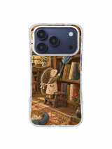 Aproned hedgehog librarian reaching toward books above a sleeping cat on an iPhone 17 Pro case