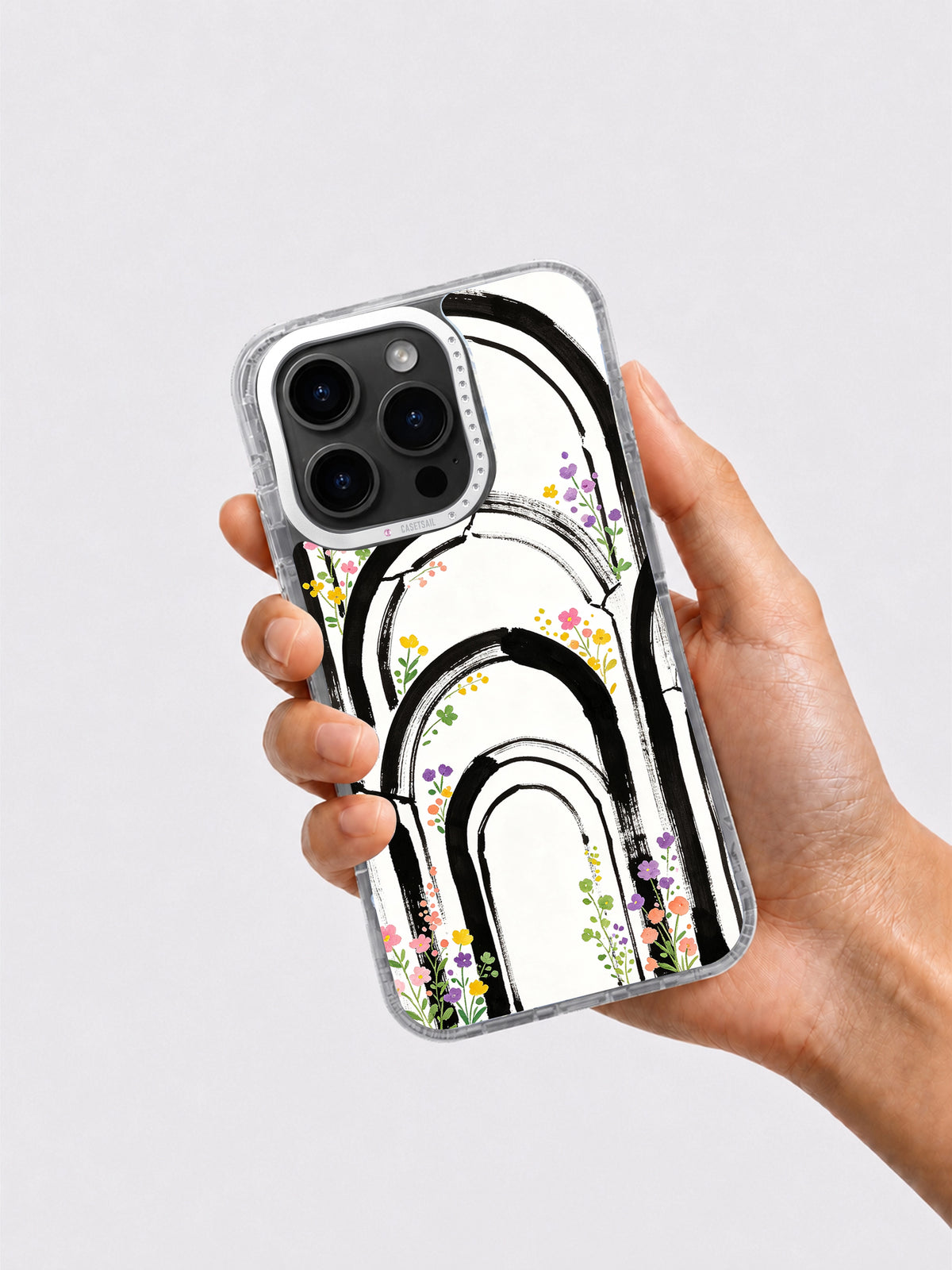 Hand holding black and white rainbow arch floral iPhone case