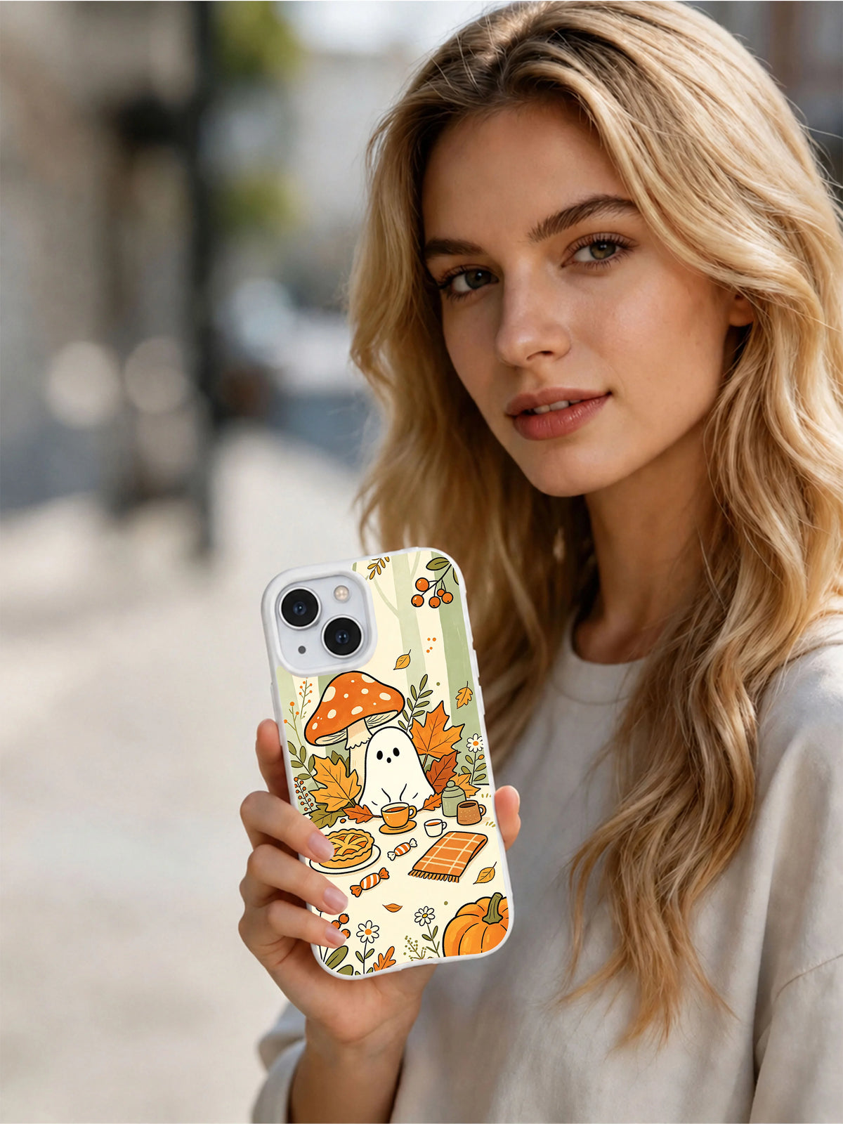 Woman holding the Ghost Tea Time in the Woods iPhone 14 case