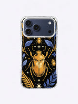 Symmetrical gold beetle on black with indigo leaves, ivory stars, and curved botanical stems
