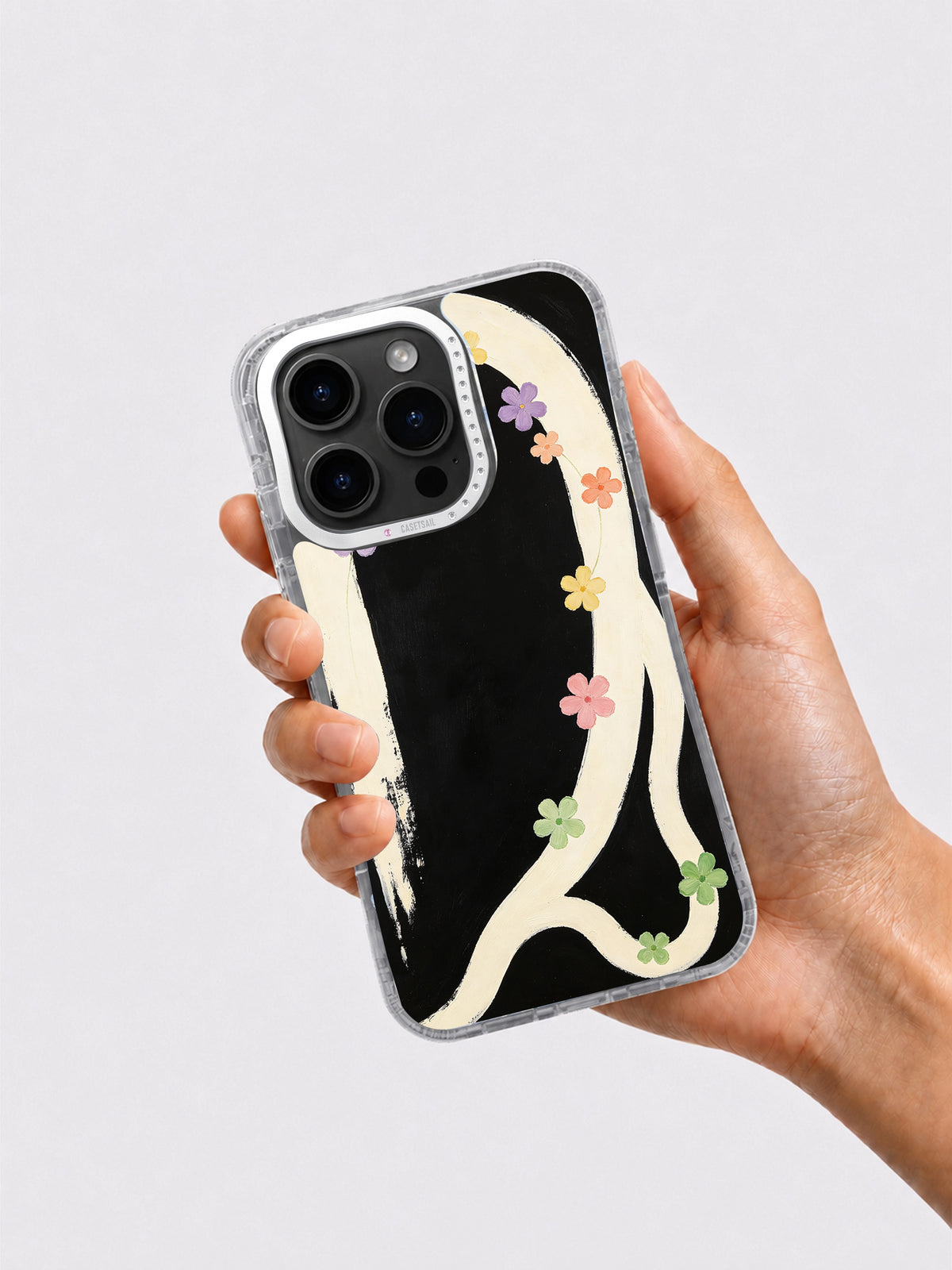 Black cream cosmic flower phone case held in hand