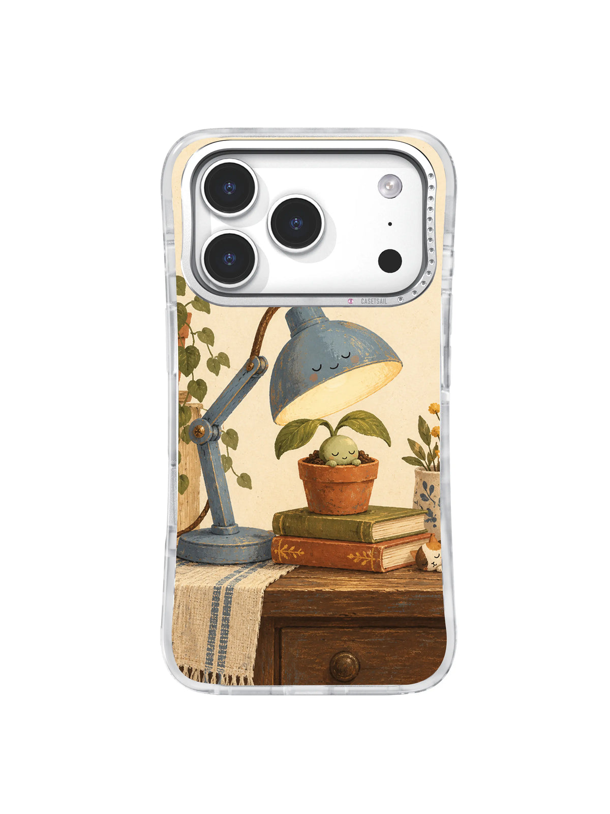 Tender seedling under a blue lamp beside old books and a wooden drawer on an iPhone 17 Pro case