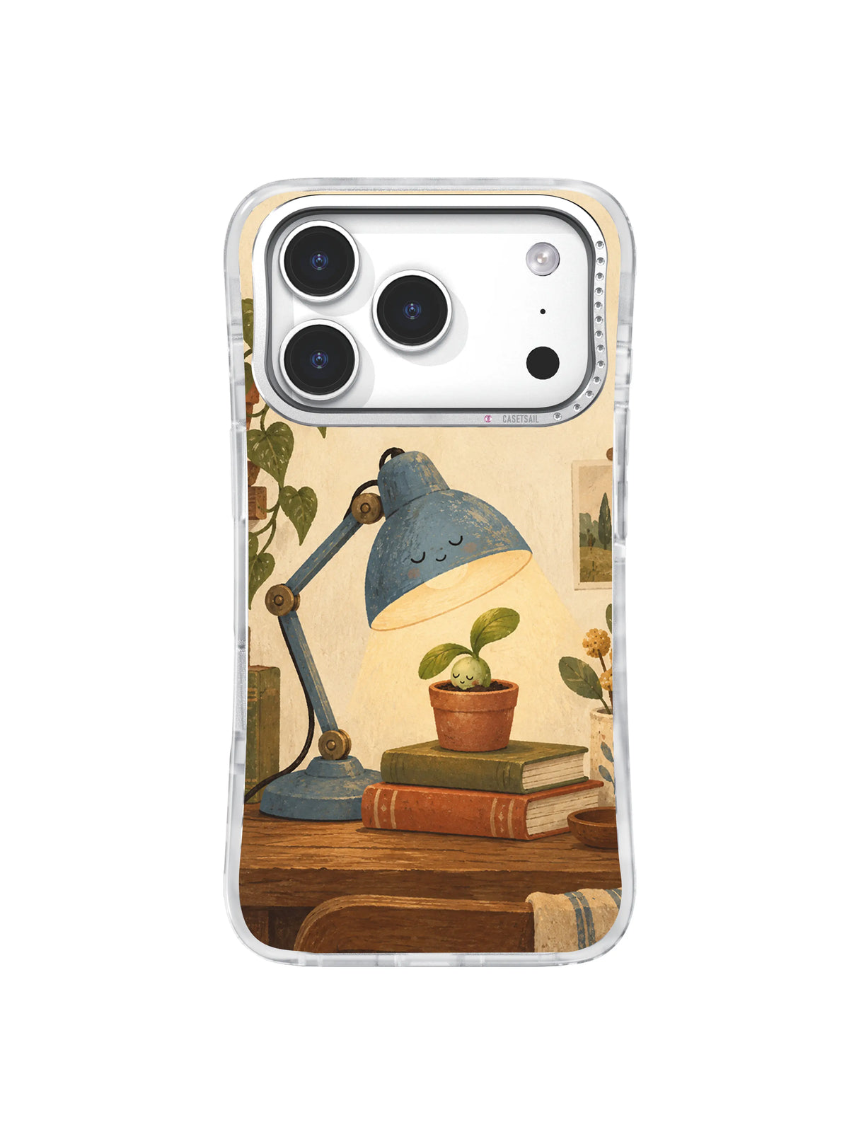 Dusty blue desk lamp watching over a seedling resting on stacked vintage books on an iPhone 17 Pro case