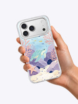 Hand holding a clear iPhone case printed with Lavender Tide Pool sea turtle art