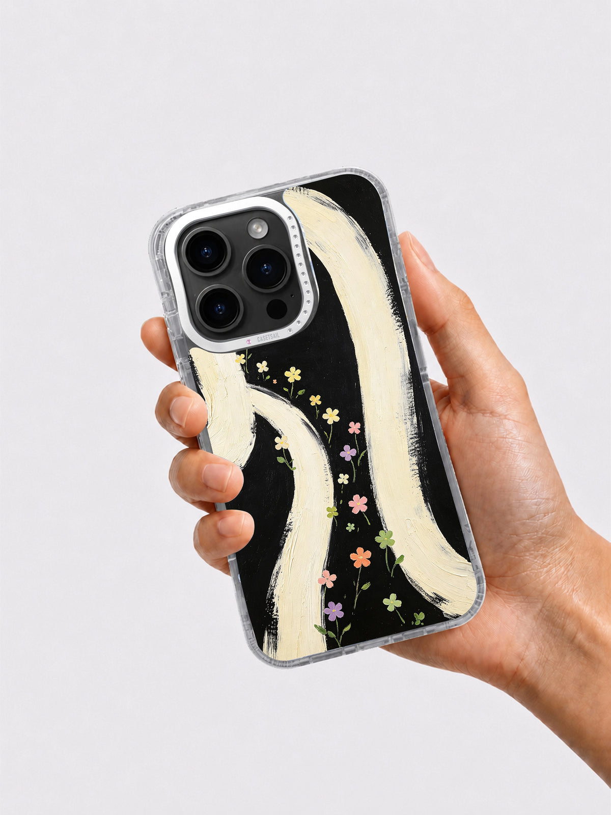 Black cream wildflower phone case held in hand