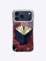 Midnight reading iPhone case with an open navy book, cream page fan, burgundy smoke, muted purple clouds, green fragments, and gold stars