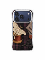Moth at the Missing Button iPhone 17 Pro Case pattern 1 with ivory moon moth, ocher thread spool and deep plum plaid