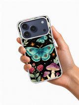 Hand holding a phone case printed with teal moths, raspberry flowers, plum mushrooms, and ochre stars