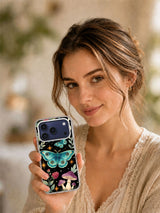 Lifestyle portrait with a phone case featuring the Peacock Moon Moths night-garden artwork