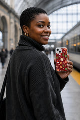 Adult woman at a train station holding the Peppermint Gift Parade iPhone 14 Plus case with Peppermint Present March artwork