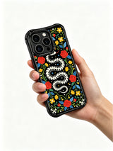 PhoneCasing iPhone 16 pro max Case featuring a coiled bone snake skeleton surrounded by bright yellow flowers, red roses and blue leaves, creating a vibrant folk art border around the design, balanced folk art design for iPhone 16 pro max casing.