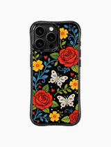 PhoneCasing iPhone 16 pro max Case featuring sugar skull butterflies with floral patterns on their wings, surrounded by red roses, yellow daisies and blue vines, folk art print on black iPhone 16 pro max casing.