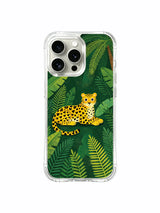 Hidden Strength: A long reclining cat lies beneath broad leaves with a looping tail.