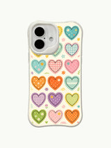 Pastel Stitches heart pattern on an iPhone 16 Plus case