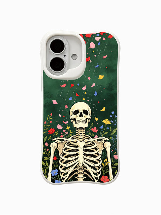 PhoneCasing Green Curtain Flower Shower fine art iPhone 16 Case, original Morrigan Vale old-school goth tattoo design featuring full-body skeleton gazing upward under drifting multicolor flower petals against vintage deep forest green textured backdrop, scratch resistant glossy iPhone 16 casing manufactured in California