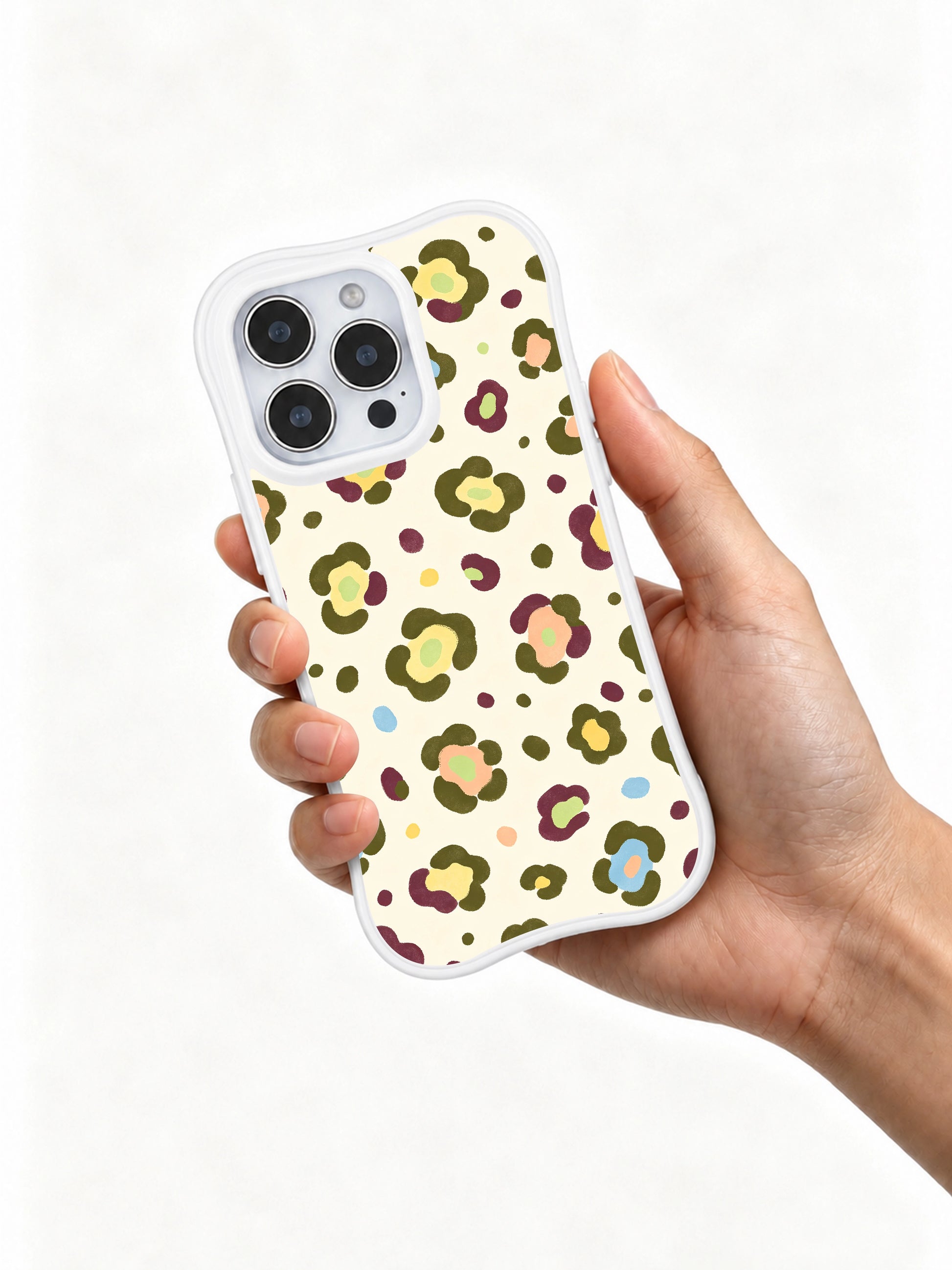 PhoneCasing iPhone 14 Pro Case clean white studio shot wearable warm garden watercolor art. Morning Bloom Leopard seamless floral spot print with soft pale cream base, gentle multi-pastel wild bloom leopard shapes, official Wild Heart Safari artist collection line.