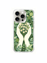Hands and eucalyptus floral totem artwork on an iPhone 15 Pro case