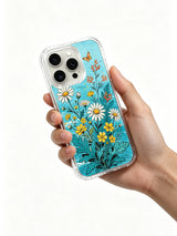  PhoneCasing summer coastal floral design on an iPhone 16 Pro Max Case, with bright white and yellow daisies against a soft ocean-blue background.