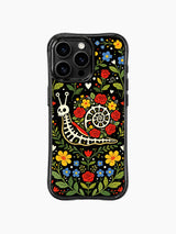 PhoneCasing iPhone 16 pro max case featuring a whimsical Day of the Dead skeleton snail surrounded by vibrant folk art flowers on black background.