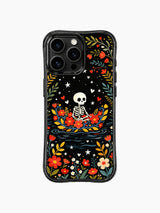 PhoneCasing iPhone 16 pro max case featuring a whimsical skeleton in a floral boat, Day of the Dead folk art design with vibrant red flowers, yellow leaves, and blue vines on black background.