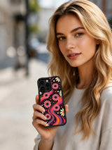 Siyah, çiçekli Tangerine Love Field telefon kılıfını tutan bir kadının yaşam tarzı görseli.