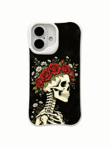 PhoneCasing lifestyle handheld Night Crown iPhone 16 Case, female model holding traditional goth skull flower crown artwork outdoors, slim lightweight scratch resistant glossy iPhone 16 cover