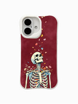 PhoneCasing Petal Ascend fine art iPhone 16 Case, vintage watercolor old school goth skeleton artwork with drifting colorful flower petals on distressed burgundy red background, scratch resistant glossy casing UV-printed in California