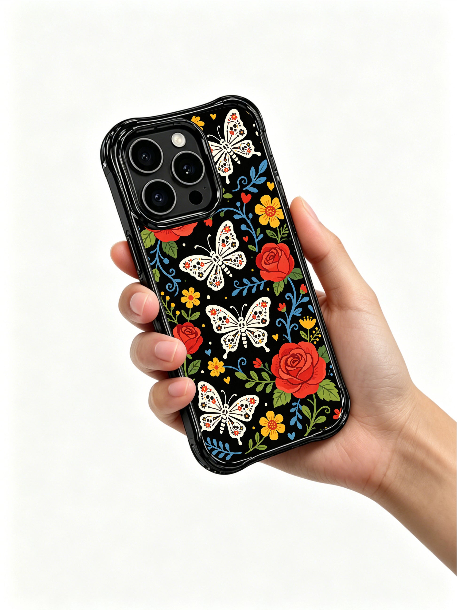 PhoneCasing iPhone 16 pro max Case featuring a single large sugar skull butterfly surrounded by red roses, yellow flowers and green foliage, set against a black background with blue scrollwork, bold folk art print on iPhone 16 pro max casing.